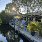 Outdoor waterfront patio at Blue Dog Bar and Grill in Matlacha Florida with canal views and diners.