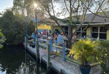 Outdoor waterfront patio at Blue Dog Bar and Grill in Matlacha Florida with canal views and diners.