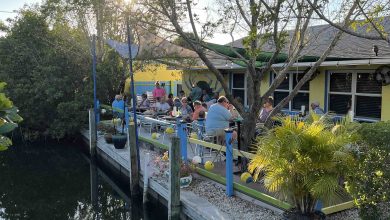 Outdoor waterfront patio at Blue Dog Bar and Grill in Matlacha Florida with canal views and diners.