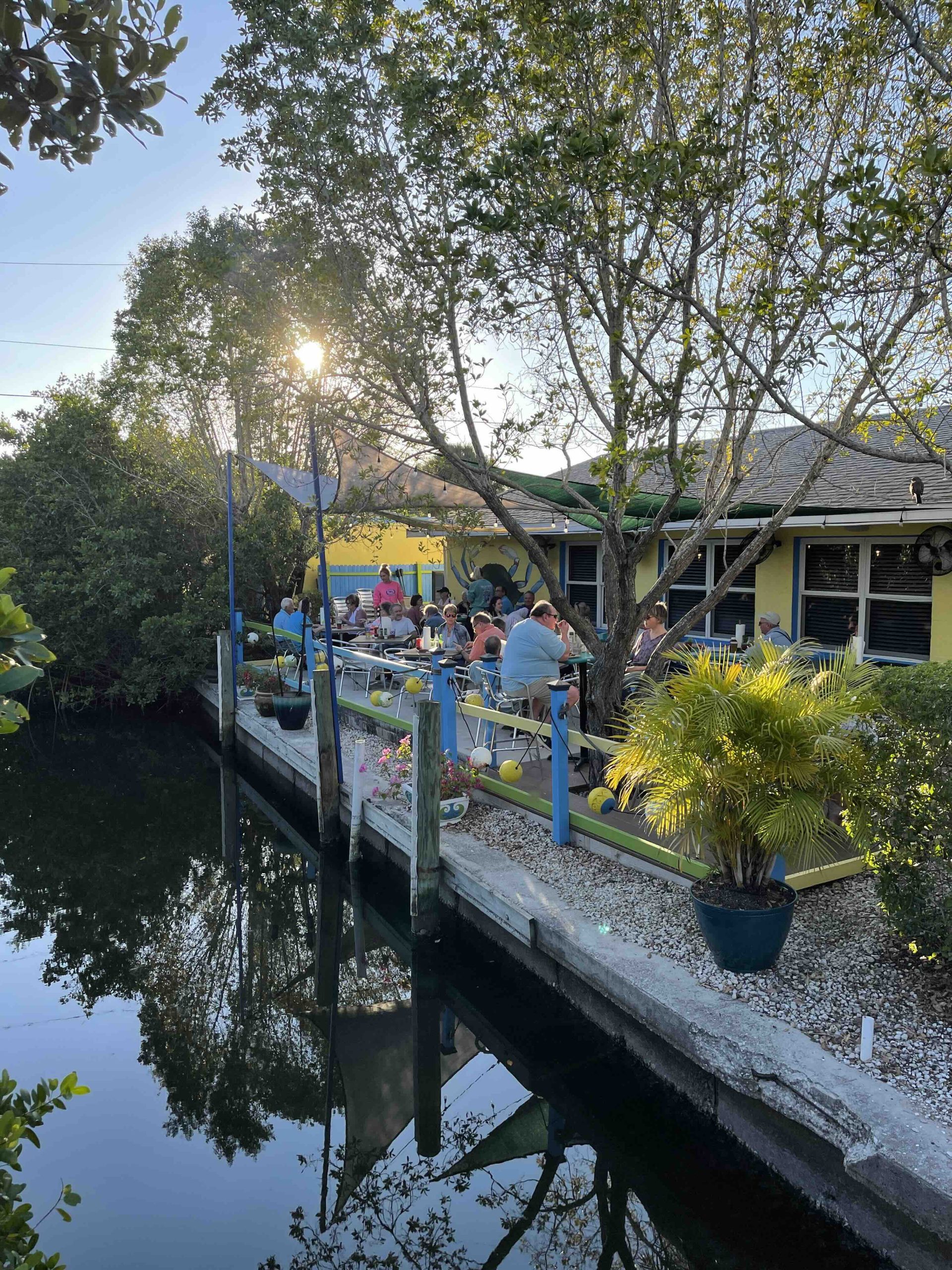 Outdoor waterfront patio at Blue Dog Bar and Grill in Matlacha Florida with canal views and diners.