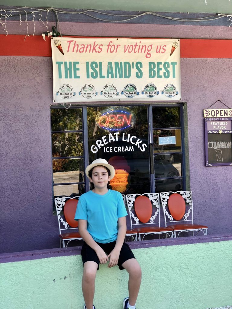 Child sitting outside Great Licks Ice Cream in colorful Matlacha Florida.