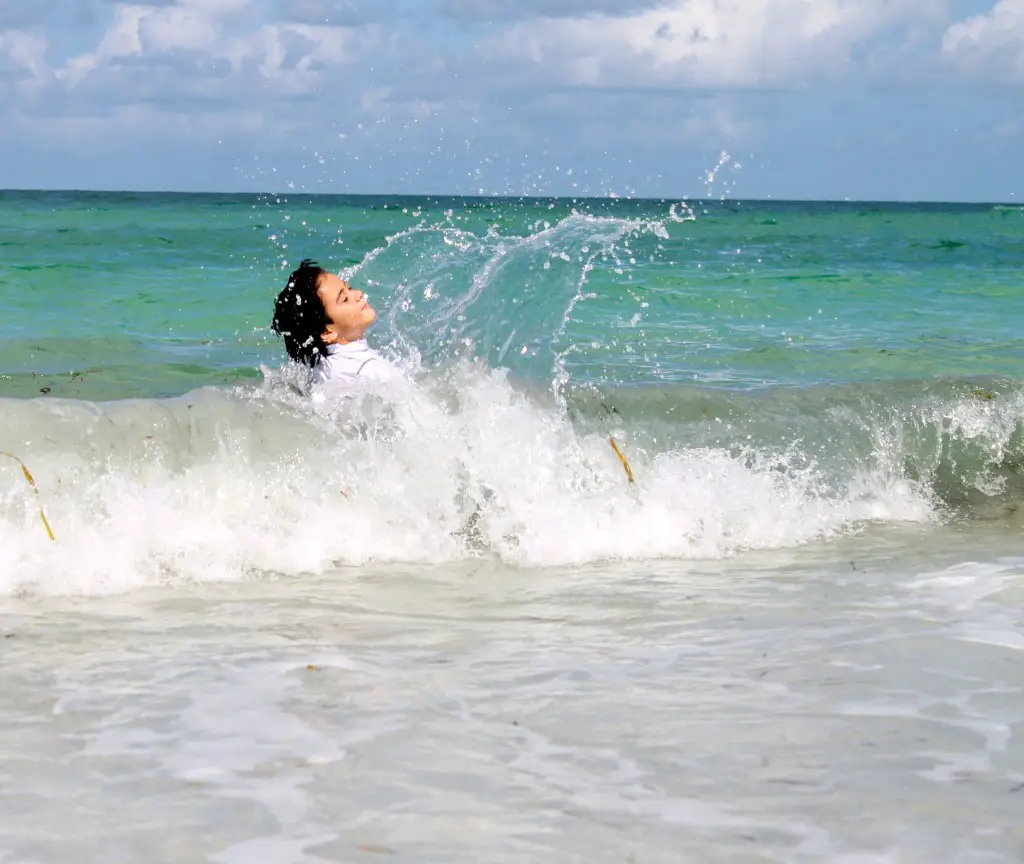 boy playing in the waves Anna Maria Island