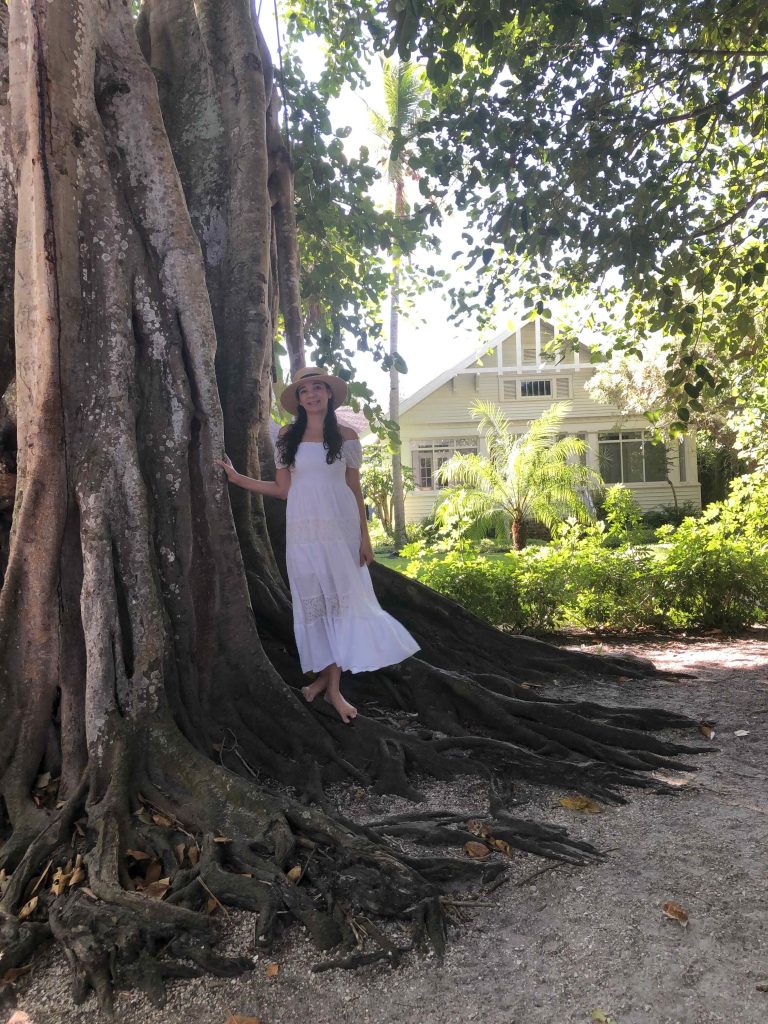 Woman standing beside the large banyan tree roots on Banyan Street in Boca Grande on Gasparilla Island